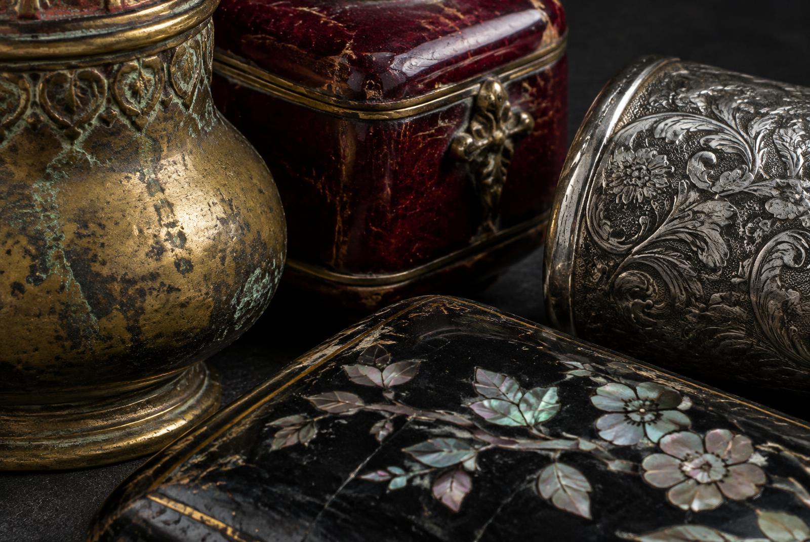 Macro study of aged brass, lacquer, engraved silver and mother-of-pearl